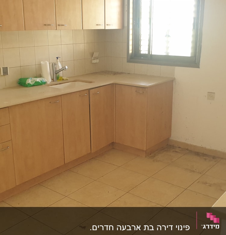 מטבח עם ארונות עץ, כיור וברז, מגבונים על השיש